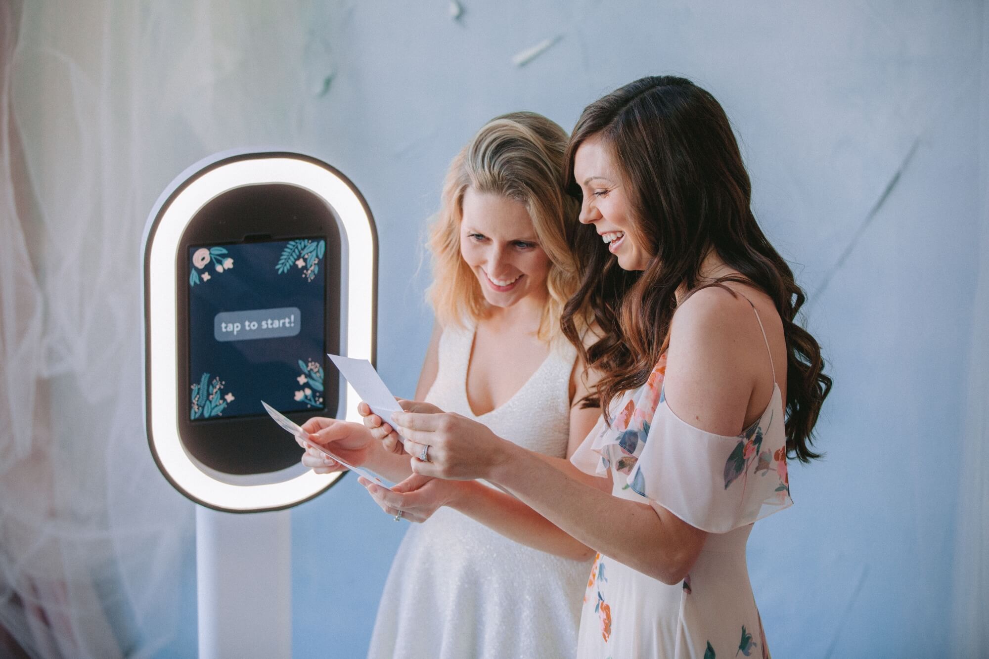 2 vrouwen kijken naar fotostrips voor een fotopaal in Amsterdam